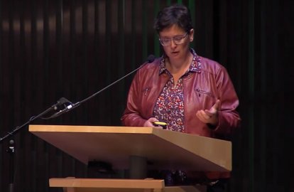 Irene van der Giessen spreekt een congres toe/ videostill